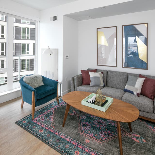 Rivage Apartments - Open Concept Living Room with Hardwood-style Flooring Overlooking Private Balcony