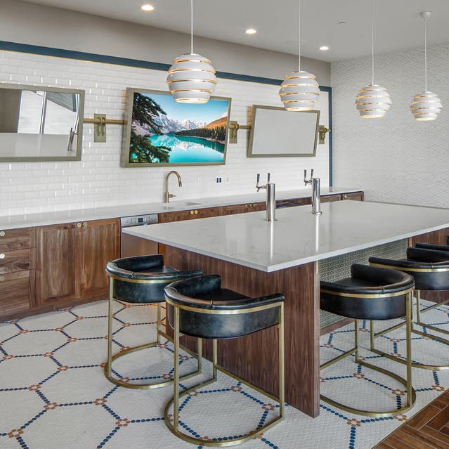 Rivage Apartments - large kitchen in clubroom with white countertops, kitchen island, and beer tap